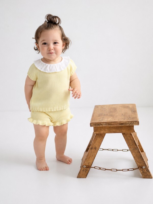 Niña morena luciendo el conjunto de braguita short en punto amarillo de la familia Primavera de Babydif, una opción de dos piezas fresca y elegante para el verano.