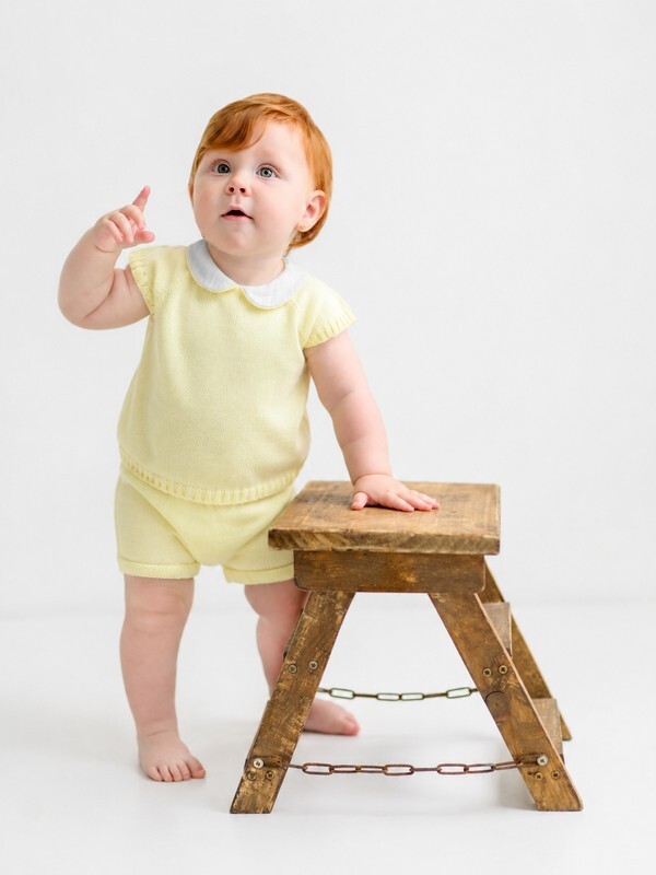 Bebé pelirrojo luciendo el conjunto de pantalón corto amarillo de la familia Primavera de Babydif, una opción cómoda y alegre para los paseos de verano.